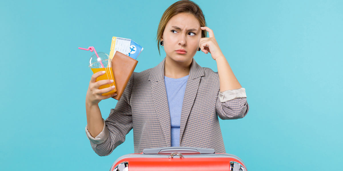 Thinking woman with her suitcase while holding a passport, plane ticket and drink cup.
