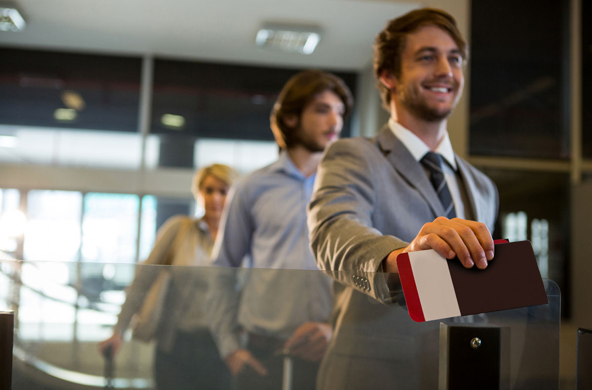 A man holding his visa while talking with an agent in front.