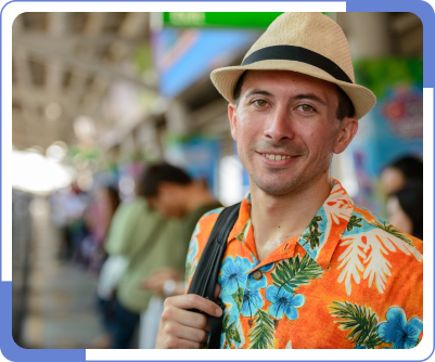 A man at a train station wearing his summer Hawaiian outfit